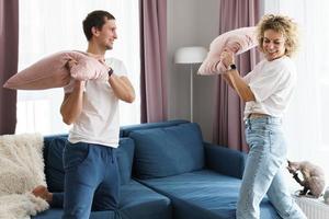 Happy couple during the pillow fight in their apartment photo