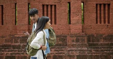 jeune homme asiatique discutant avec une belle femme demandant un numéro de téléphone à l'ancienne thaïlande. homme et femme marchant l'un en face de l'autre. concept de vacances, de voyage et de passe-temps. video