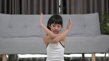 toma en cámara lenta, niña asiática sentada en una alfombra entrenando con una tableta en pose de meditación en casa video