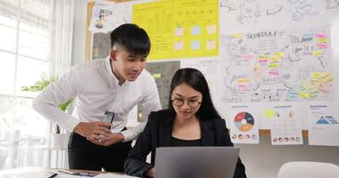 asiatischer mann teamleiter coach mentor mit mitarbeiter beim telefonieren bei firmentreffen. asiatische arbeiter diskutieren gemeinsam im konferenzraum während des treffens im büro. video