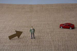 flecha y una figura de hombre y un coche de juguete rojo