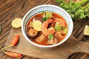 Tom Yum Kung Spicy Thai Soup with Shrimp and Squid in a Chinese Ceramic Bowl photo