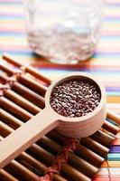 close up of flax seeds on wooden spoon on table photo