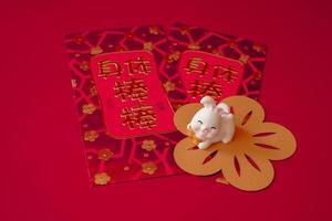 año nuevo chino del concepto del festival del conejo. conejo en sobres rojos aislado sobre fondo rojo. feliz año nuevo conejo chino 2023. los caracteres chinos significan rico, rico, saludable y feliz. foto