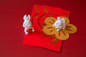 Chinese New Year of the rabbit festival concept. Rabbit on red envelopes isolated on red background. Happy New Year Chinese Rabbit 2023. photo