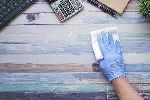 mano en una vista superior del escritorio de oficina de limpieza de guantes foto