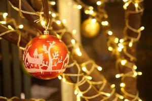 Christmas and New Year Decoration. Hanging Baubles close up. Abstract Blurred Bokeh Holiday Background. Blinking Garland. Christmas Tree Lights Twinkling. photo