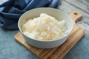 slice of fresh coconut flakes in a bowl on a table photo