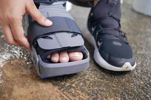 mujeres pies rotos con una bota de plástico gris tobillera protección contra lesiones bota foto