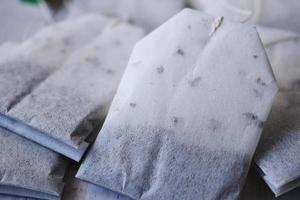 tea bags and yellow color mug on table photo