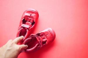 mujeres con zapatos para niños sobre fondo rojo foto