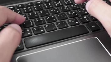 mannens fingrar skriver tangentbord svart på laptop, flitig skriver. video