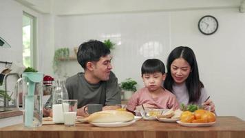 konzept aktivitäten familie im urlaub. Eltern und Kinder essen in den Ferien gemeinsam. der Sohn gibt vor, seinen Vater mit Brot zu füttern. video