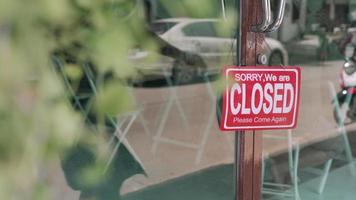 kvinnlig ägare har bytt tagg från stängd till öppen för att börja sälja. ägare småföretag öppnade en butik efter en lång tids effekt av det epidemiska viruset. affärsrehabiliteringskoncept. video