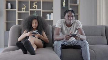 Father is teasing and teasing daughter during fun playing console games on vacation day. Daughter and father have Holiday family activities. Family concept.