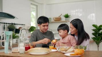 activités de concept famille en vacances. parents et enfants mangent ensemble pendant les vacances. le fils fait semblant de donner du pain à son père. video
