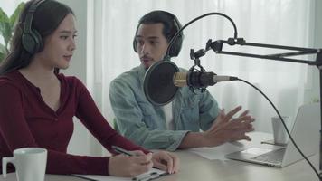 Team podcast speaking on a morning radio station broadcasting a news program and men preparing the content via computers.woman and men smiling and happy during on air live steaming video