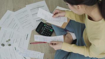 Debt credit and financial problem concept. Asia woman is sitting and recheck on invoices and stress because not manage debt on month. woman covering face with hands and feel stressed. video