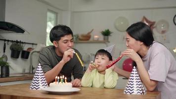 Family activities on holiday. Father and mother are host a birthday party for their son is 5 years old. Father and mother are singing happy birthday song for the child to blow a cake on his birthday video
