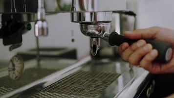 barista bereiden koffie volgens naar de recept. eigenaar van een klein koffie winkel is brouwen koffie met arabica koffie bonen voor dienen naar de klanten. barista zetten grond koffie in de koffie maker. video