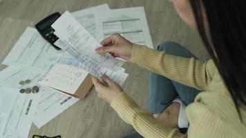 Debt credit and financial problem concept. Asia woman is sitting and recheck on invoices and stress because not manage debt on month. woman covering face with hands and feel stressed. video