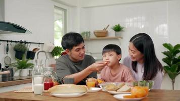 atividades família nos feriados e finais de semana.filho lambia alegremente uma laranja porque era sua fruta favorita. pais e filhos fazem uma refeição juntos durante as férias. video