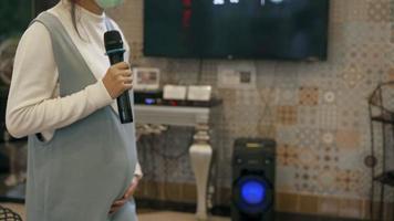 un' 4 mese incinta donna gode cantando karaoke e danza per il battere di il canzone. bonario donna video