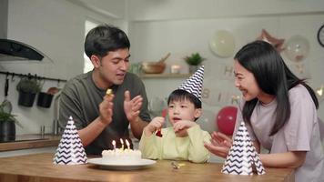 Family members have fun together by blowing toys on their son's birthday. ,Son plays with toys and smiles happily when mom and dad hold birthday parties. video
