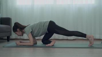 mujer delgada de asia practicando yoga en condominio. hermosa mujer haciendo ejercicios en la mañana. equilibrio, recreación, relajación, calma, buena salud, feliz, relax, estilo de vida saludable, reducir el estrés, pacífico. video