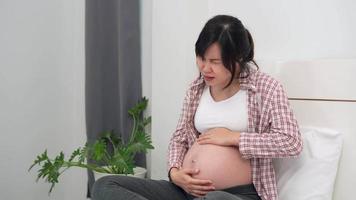 pregnant woman is experiencing severe pain as a result of the normal. Symptoms of abdominal and back pain begin to appear more with the increasing gestational age. concept pain during pregnancy. video