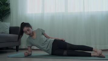 femme asiatique mince pratiquant le yoga sur le condo. belle femme faisant des exercices le matin. équilibre, loisirs, relaxation, calme, bonne santé, heureux, détente, mode de vie sain, réduction du stress, paisible. video