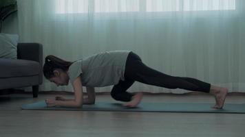 smal Asien kvinna praktiserande yoga på lägenhet. skön kvinna håller på med övningar i morgon. balans, rekreation, avslappning, lugna, Bra hälsa, Lycklig, koppla av, friska livsstil, minska påfrestning, fredlig. video