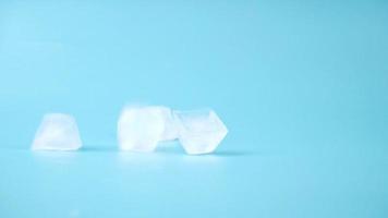 falling cooling ice cubes on blue background, frozen water for drink video