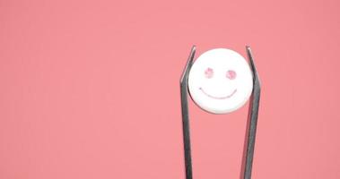 Lycklig leende piller i pincett stänga upp, lsd läsplatta för Bra psykoaktiva resa på rosa bakgrund video