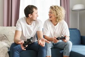 Couple with a gamepads are playing video game console photo