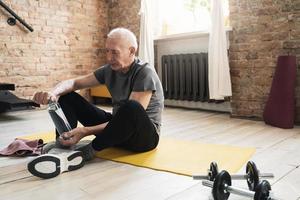 anciano relajándose después de su entrenamiento de fitness en casa foto