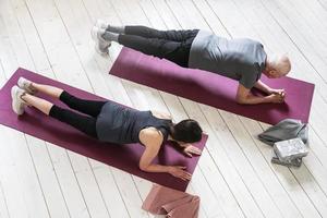 Active elderly people working out on the exercise mats at home photo