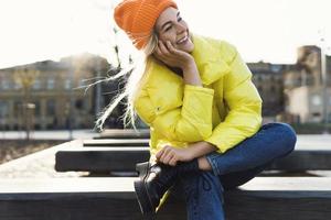 Stylish girl wearing yellow puffer and orange knitted hat photo