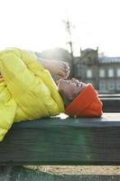 Stylish girl wearing yellow puffer and orange knitted hat photo