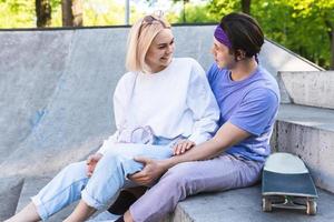 Happy and loving teenage couple in a skatepark photo