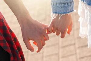 Couple holding hands with a pinky grip photo