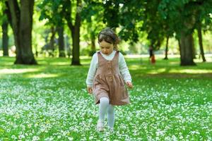 linda niña camina en un parque de la ciudad foto