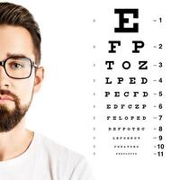 Man wearing eyeglasses and eye chart for visual acuity test photo