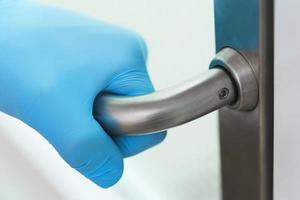 Doctor's hand on the metal door handle photo