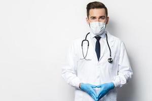 Doctor with the stethoscope wearing prevention mask and latex gloves photo