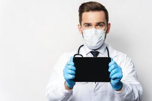 Young and confident doctor is using tablet pc photo