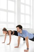 Fitness man and woman during workout with in the gym photo