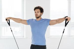 Young man during workout with a resistance bands in the gym photo