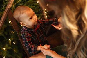 Little boy wearing checkered shirt at home during Christmas eve. photo