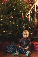 Little boy wearing checkered shirt at home during Christmas eve. photo